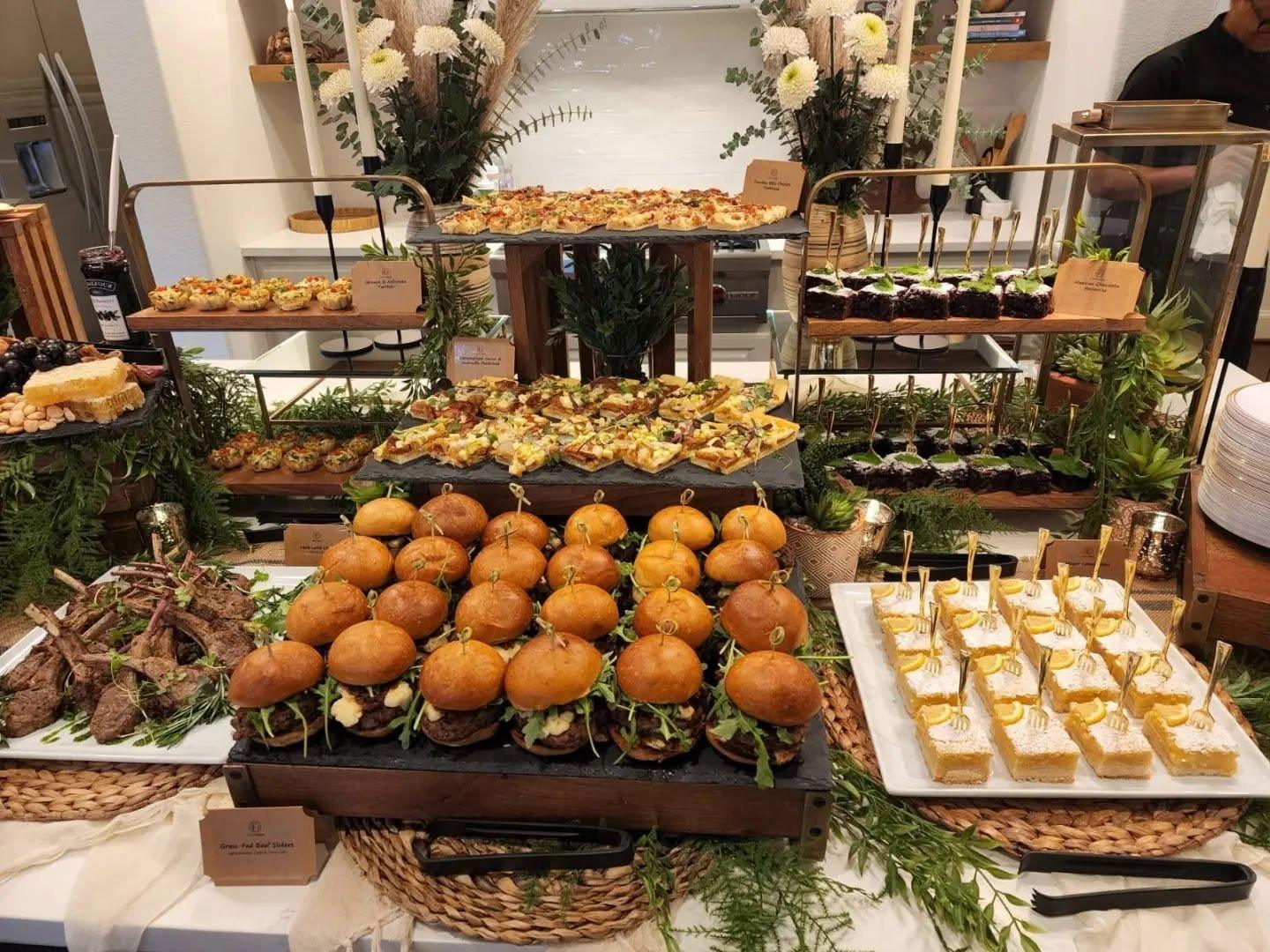 A catered buffet with sliders and tiered displays