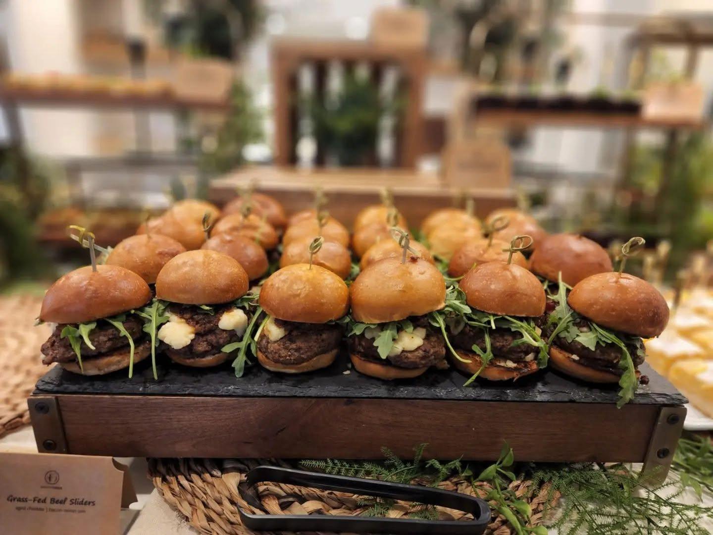 Grass-fed beef sliders with aged cheddar and arugula on a display