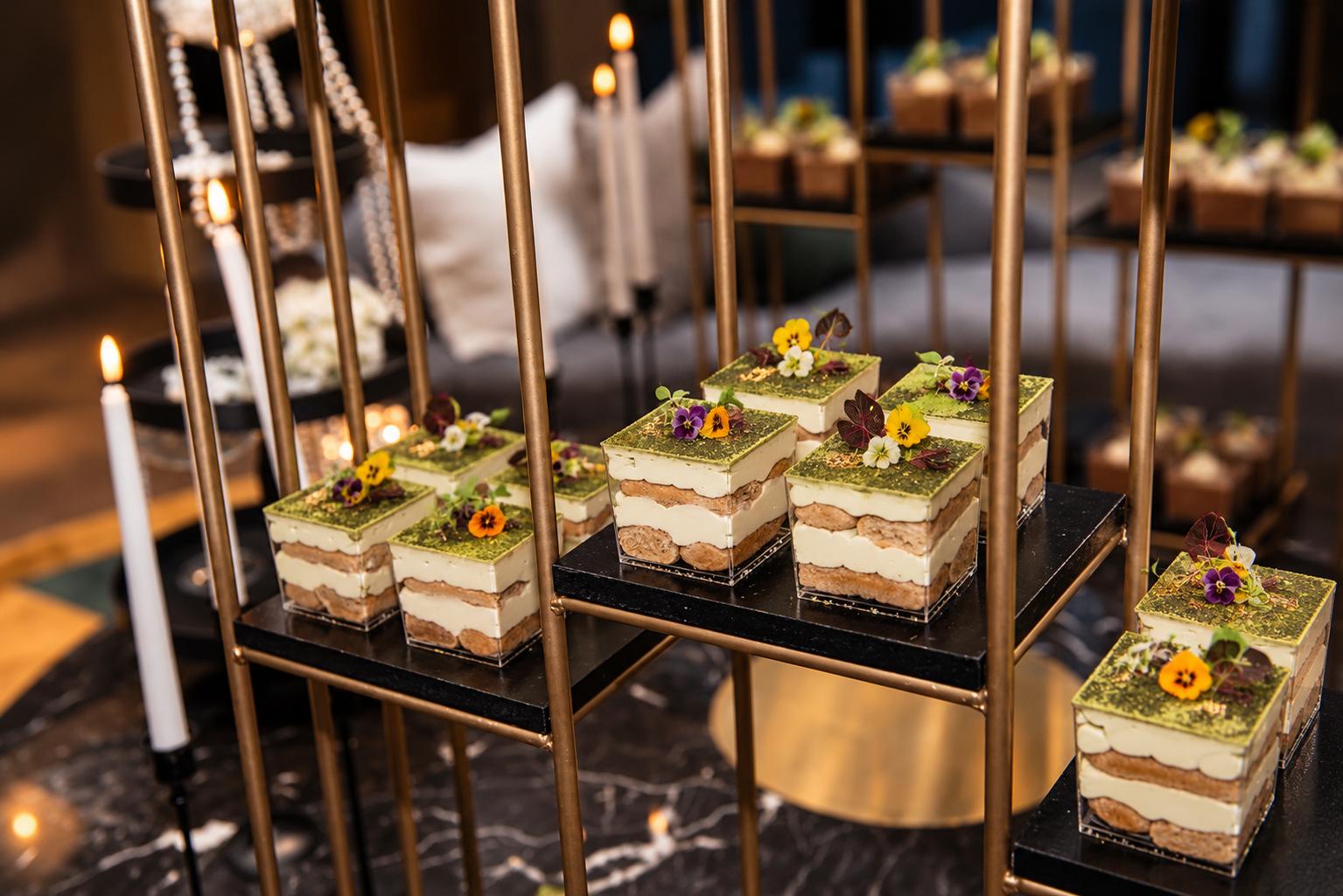 Layered matcha desserts with edible flowers on a gold tiered stand