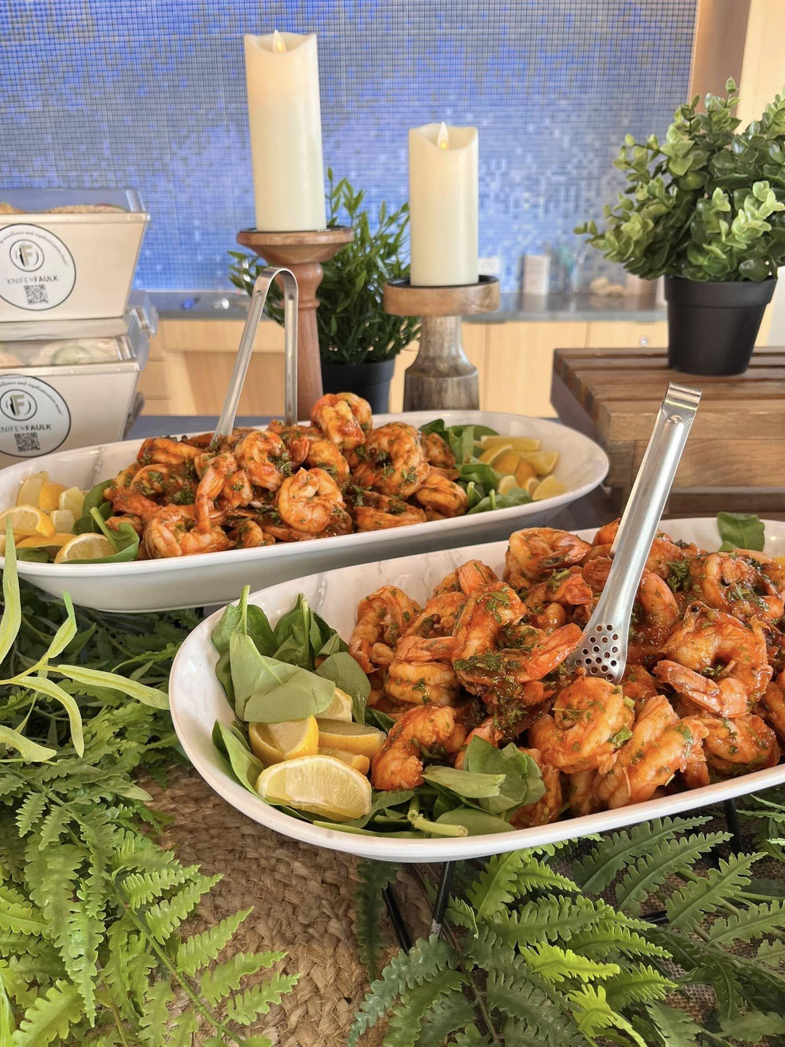 Grilled shrimp on a buffet display with fresh greenery