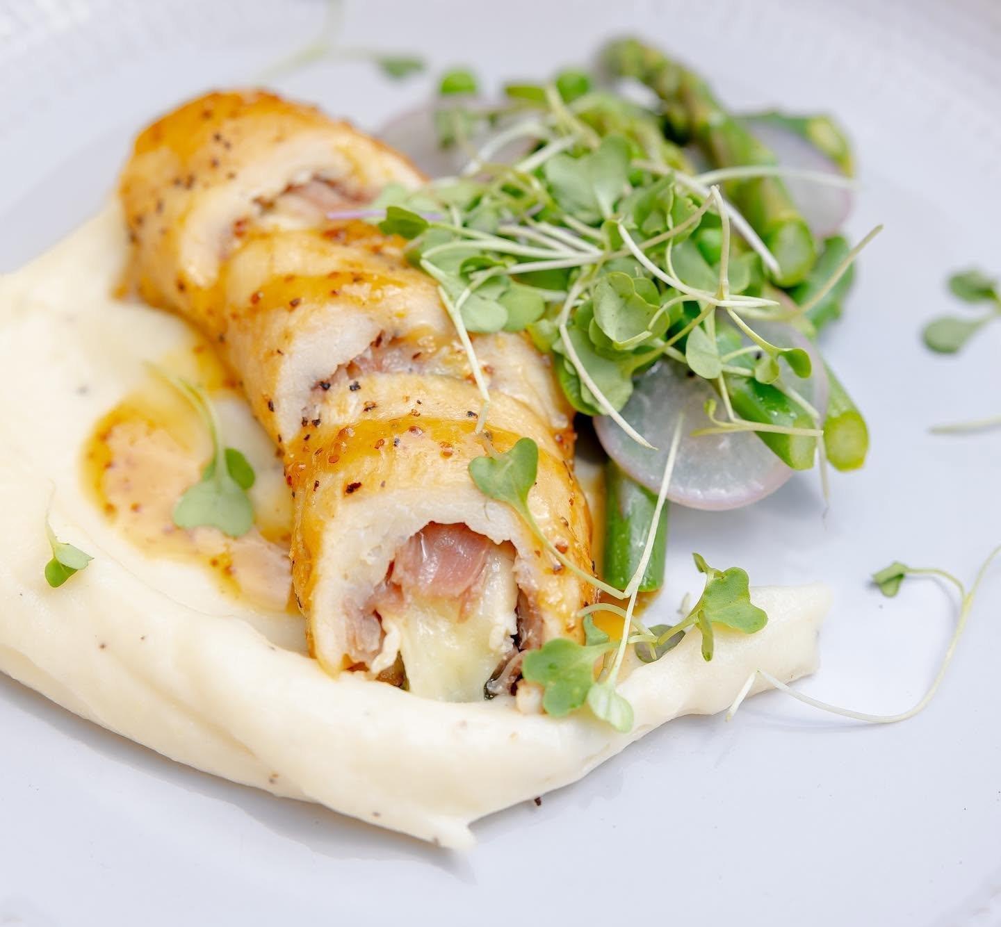 Stuffed chicken roulade over whipped potatoes with microgreens